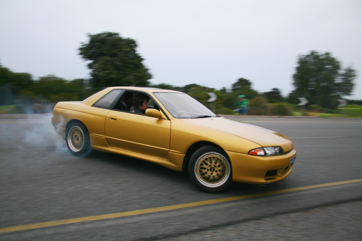 yellow car drifting on road