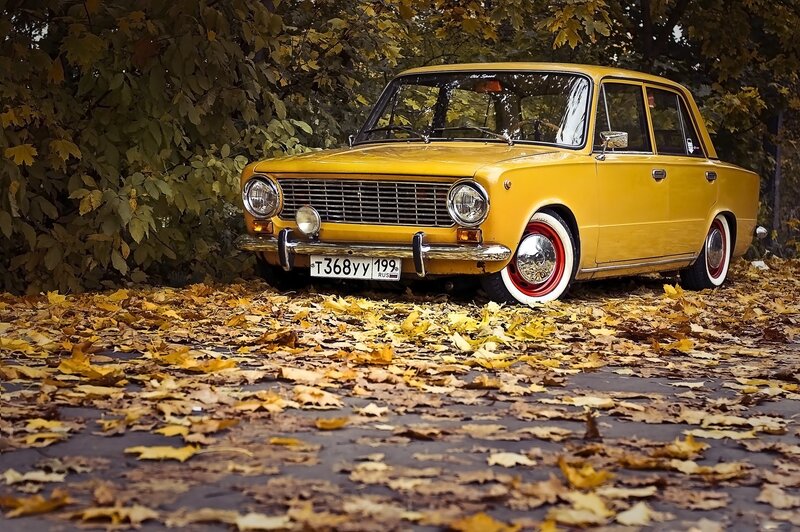 Yellow car in autumn leaves
