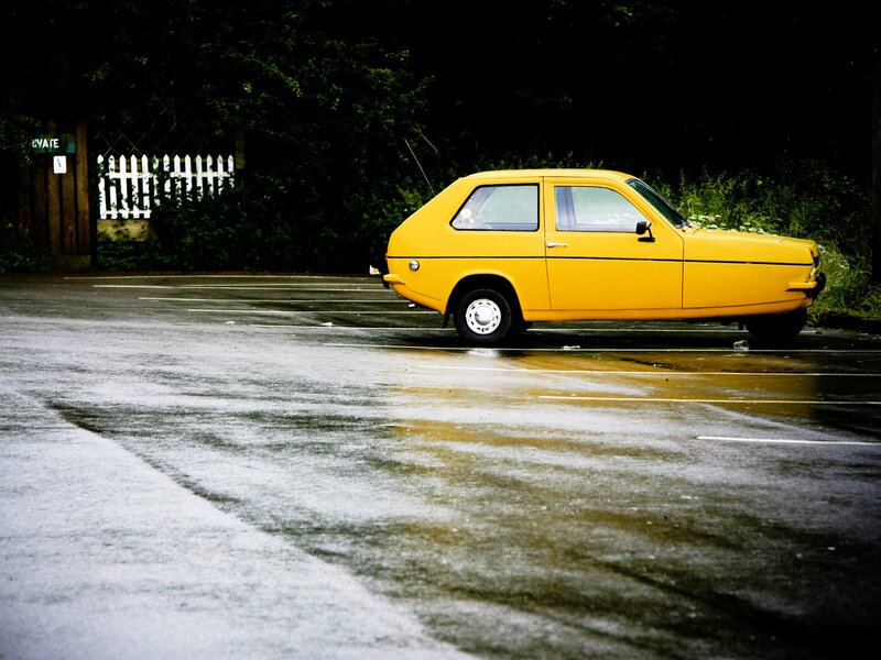 Yellow car in wet parking lot