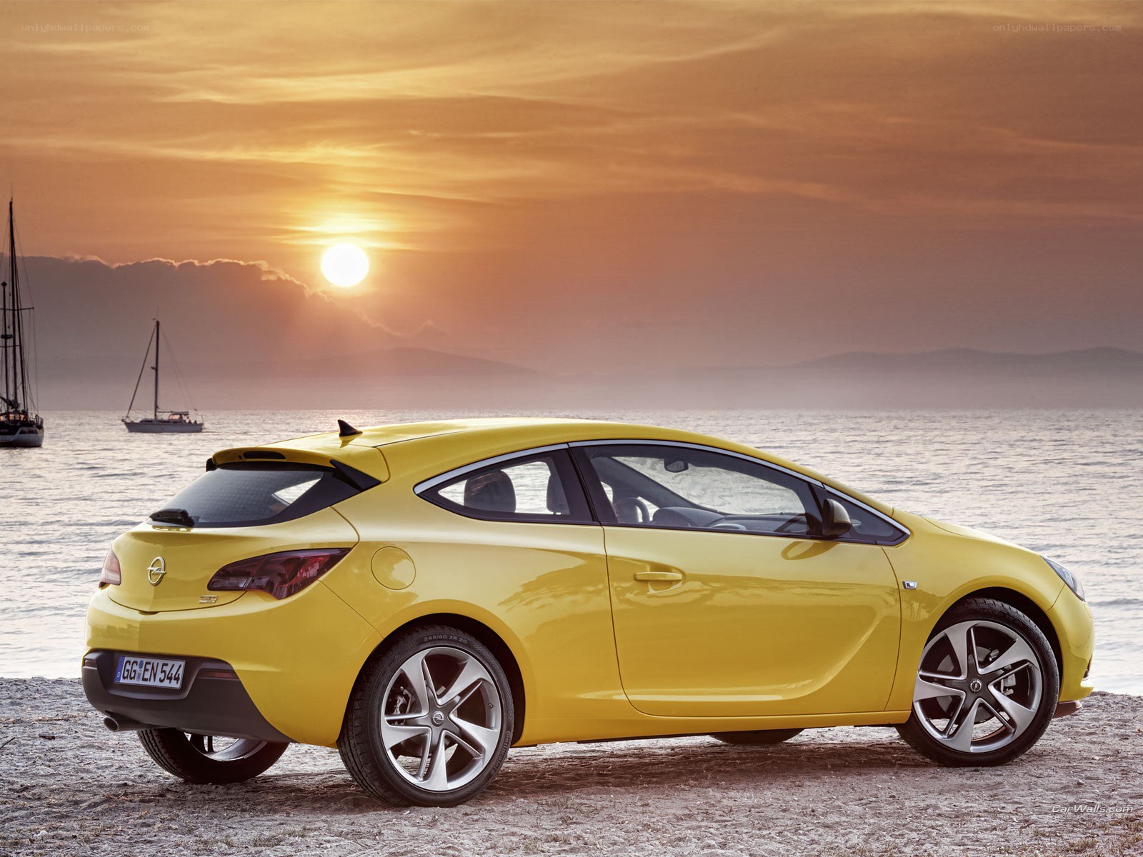 Yellow car on beach at sunset