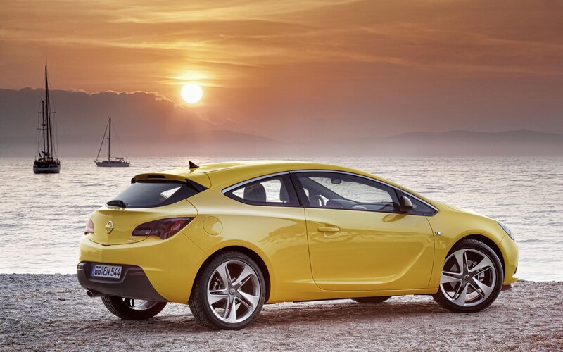 Yellow car on beach at sunset