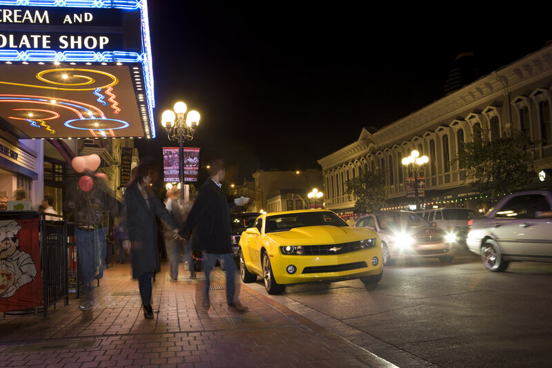 Yellow car on city street at night