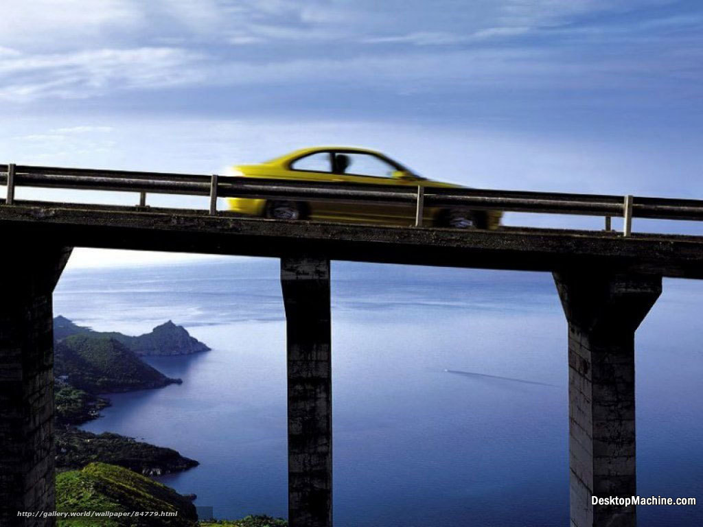 Yellow car on coastal bridge