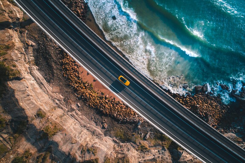 Yellow Car on Coastal Road — Blue
