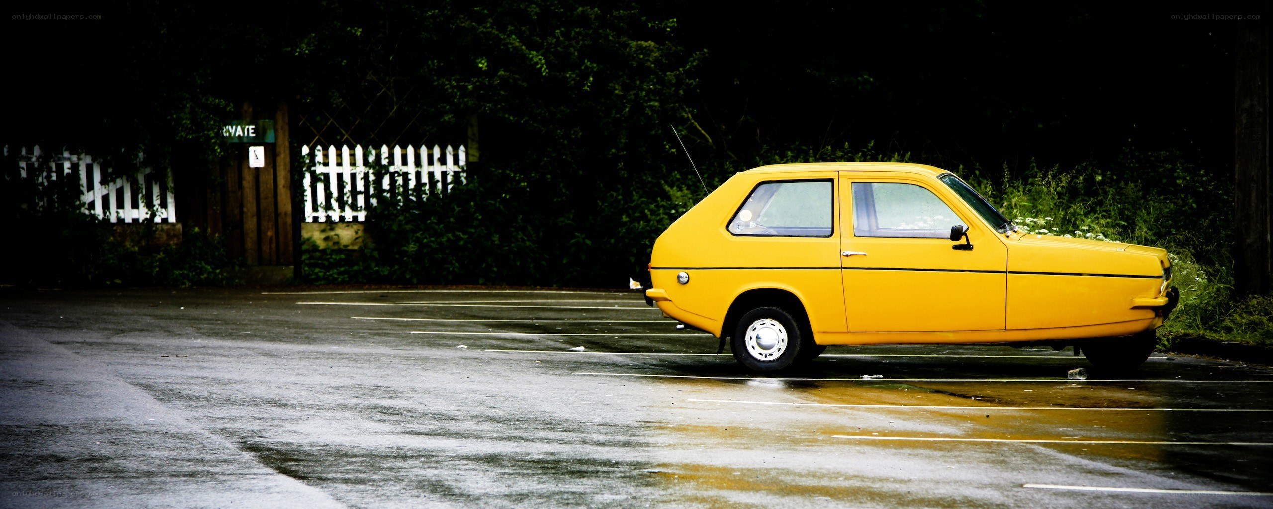Yellow car on wet pavement