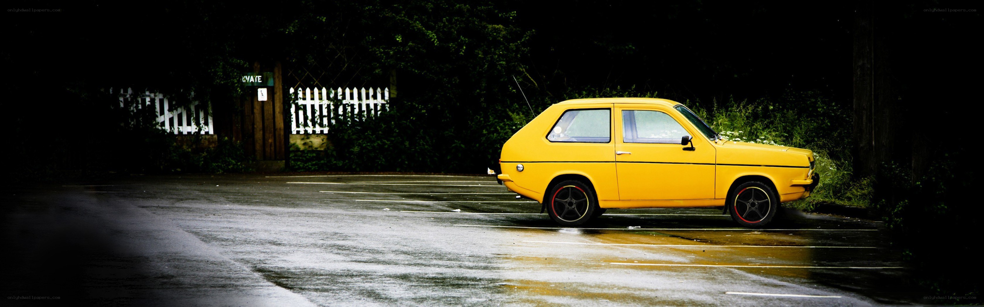 Yellow car on wet pavement