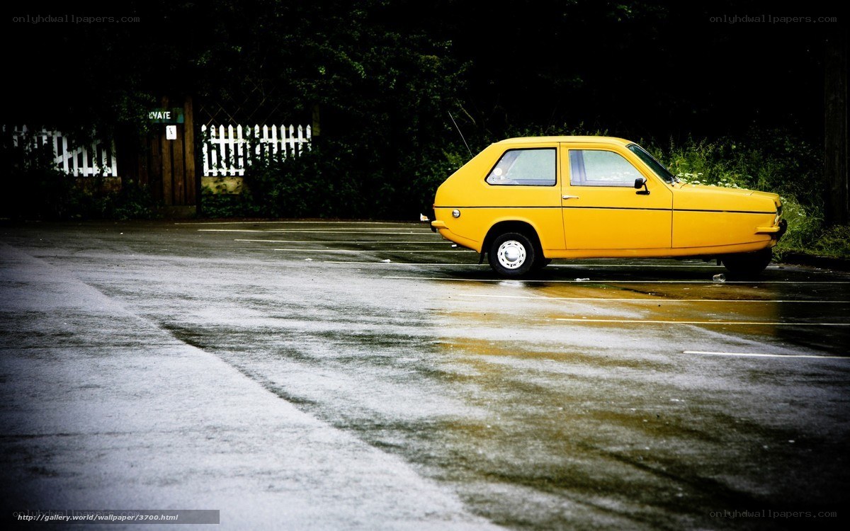 Yellow car on wet pavement