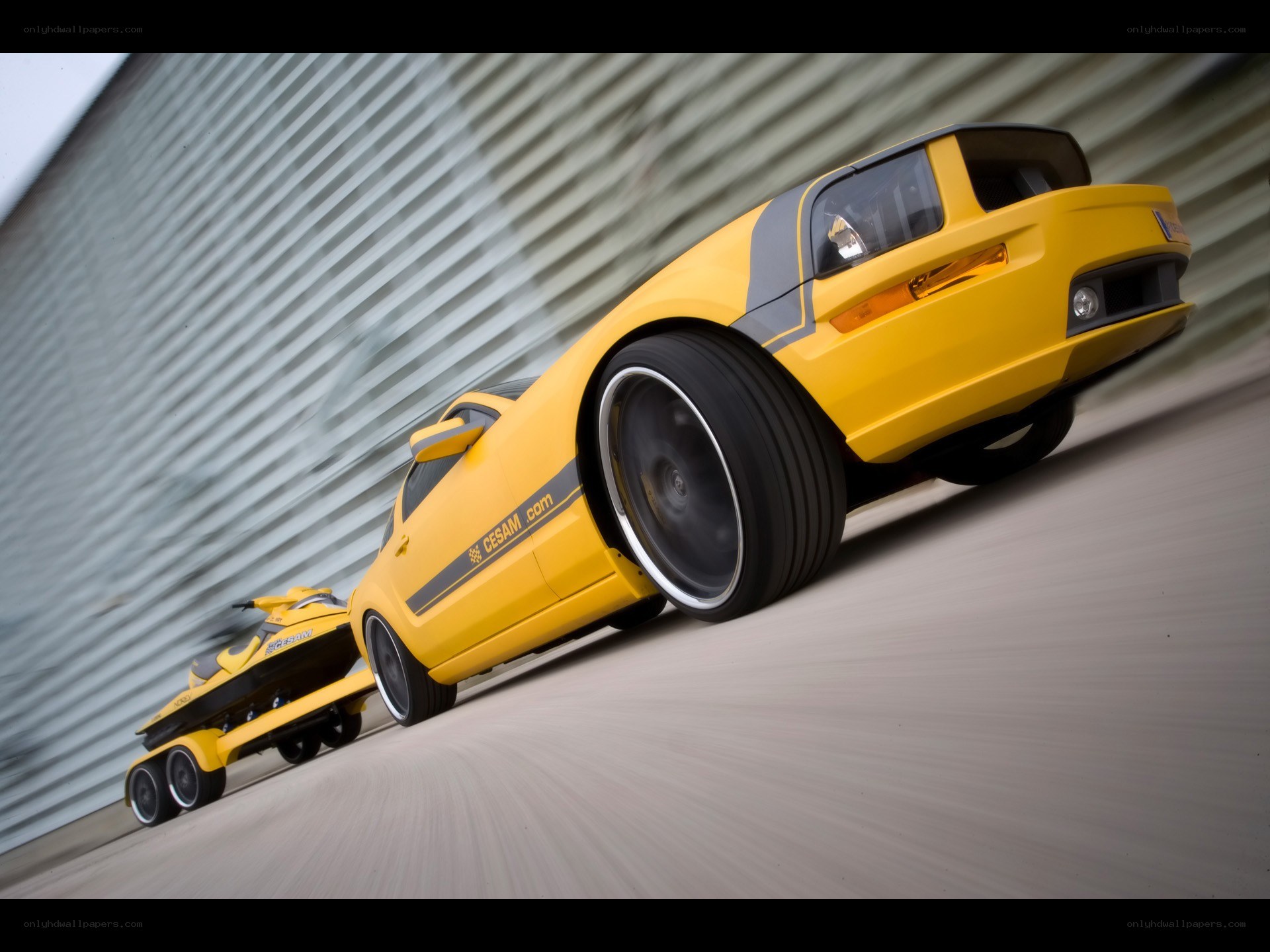 yellow car towing jet ski