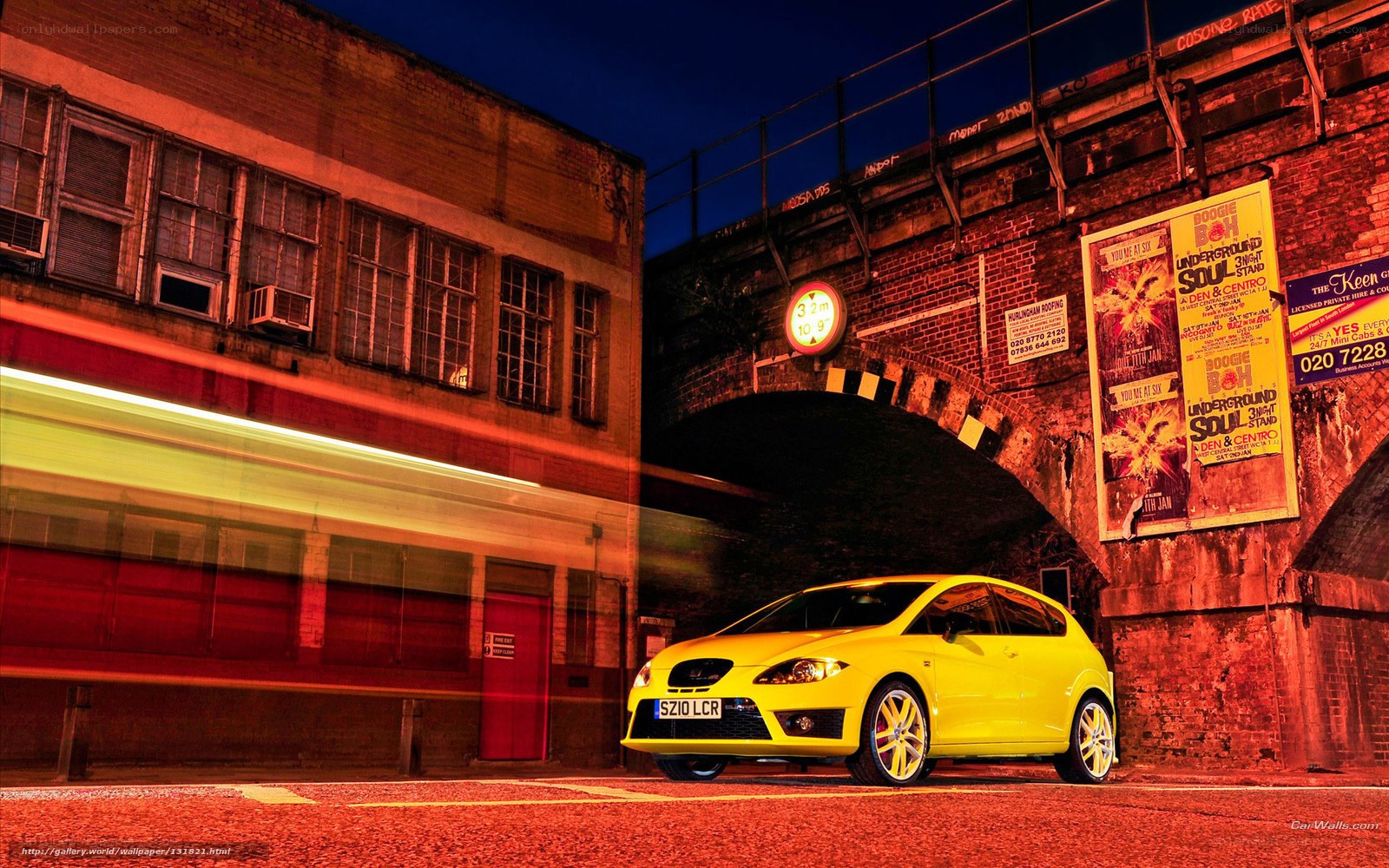 Yellow car under railway bridge