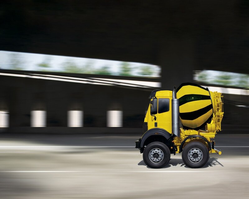 Yellow cement mixer truck in motion