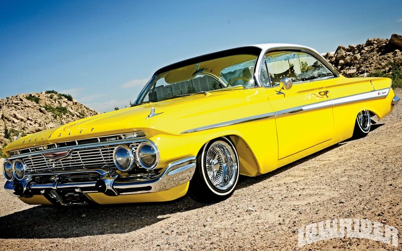 yellow classic car on gravel