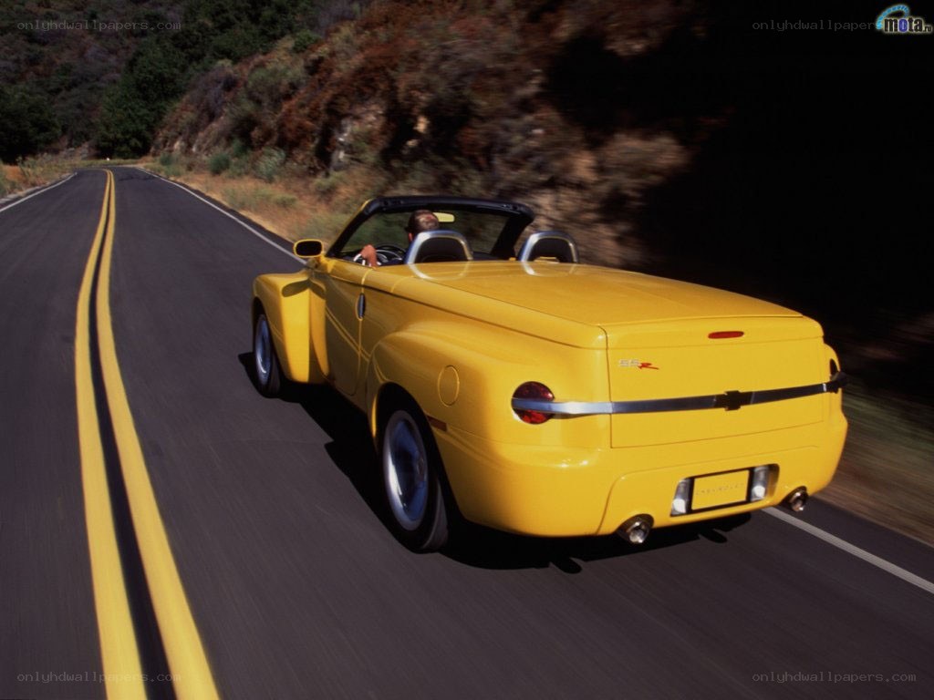 yellow convertible on winding road