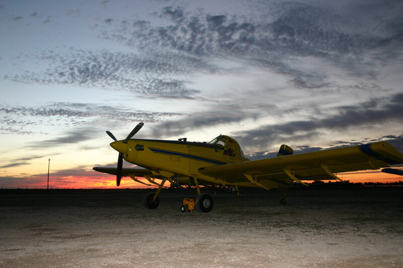 Yellow crop duster at sunset