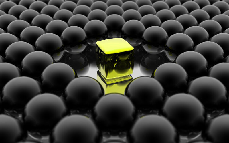 yellow cube among black spheres
