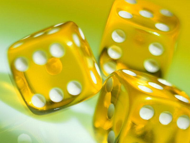 Yellow dice on a green surface