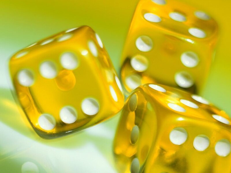 Yellow dice on green background