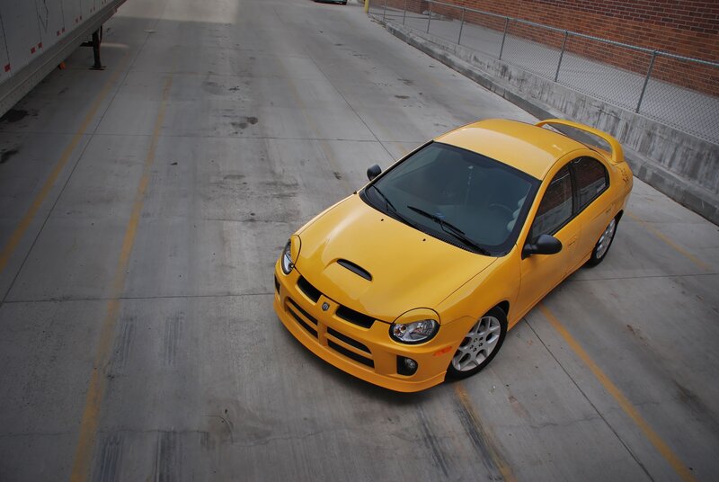 yellow dodge neon parked in lot