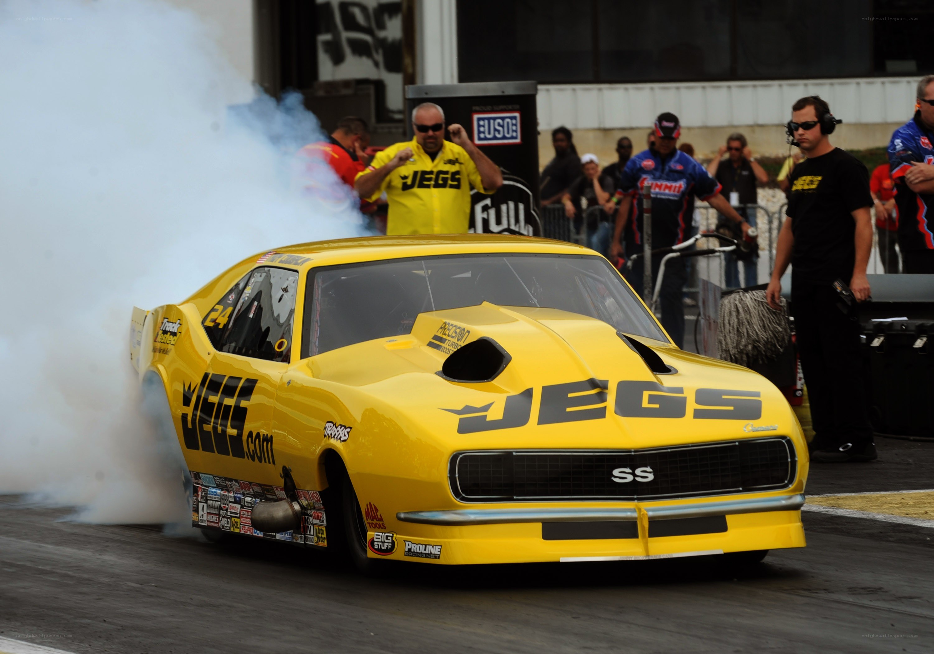 Yellow drag racing car performing burnout