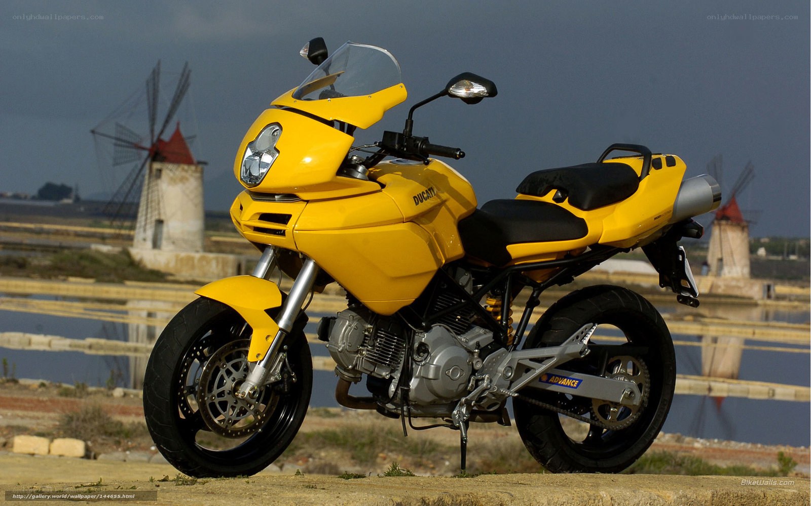 Yellow Ducati motorcycle with windmills