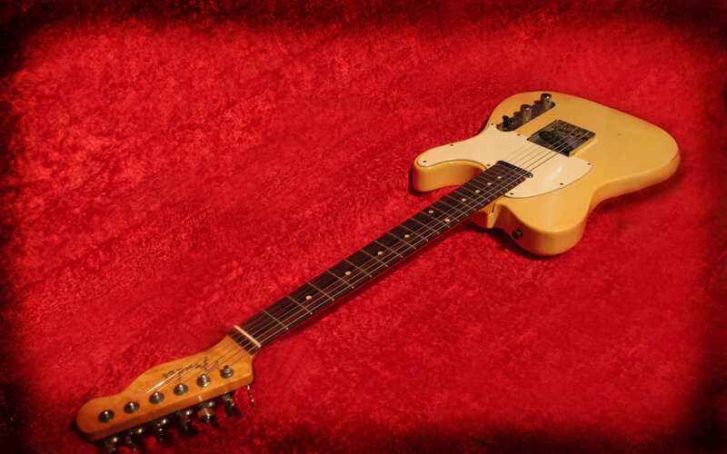 yellow electric guitar on red