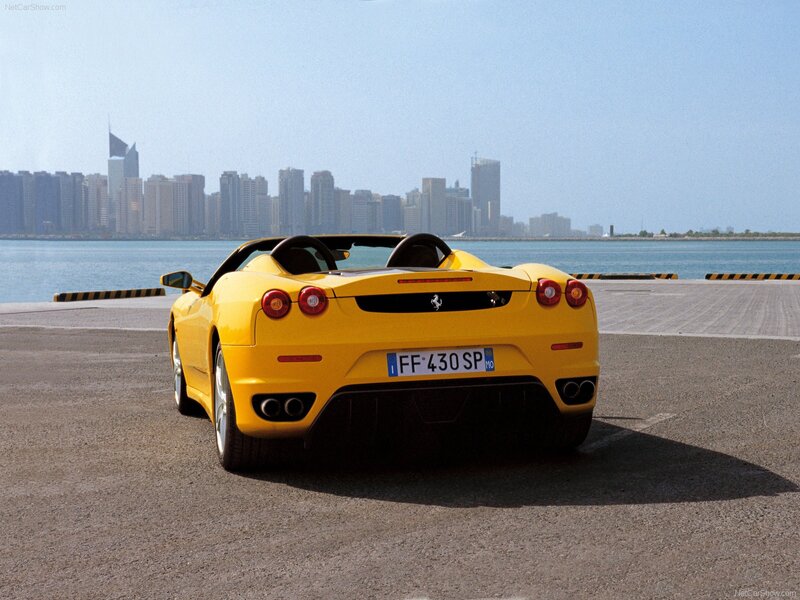 Yellow Ferrari convertible by the water