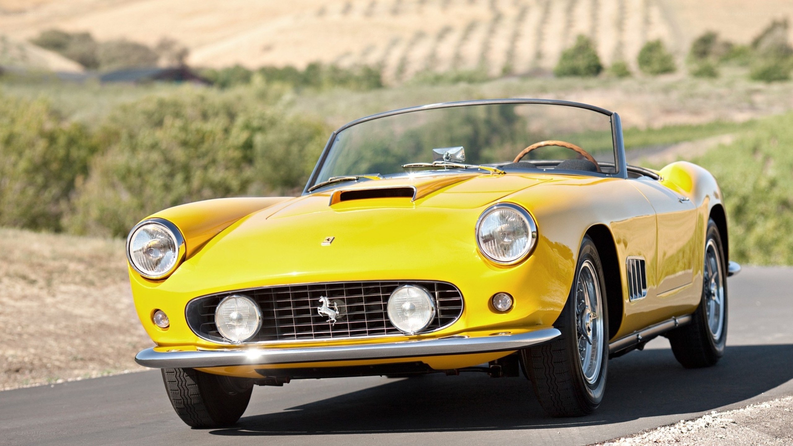 Yellow Ferrari convertible on road