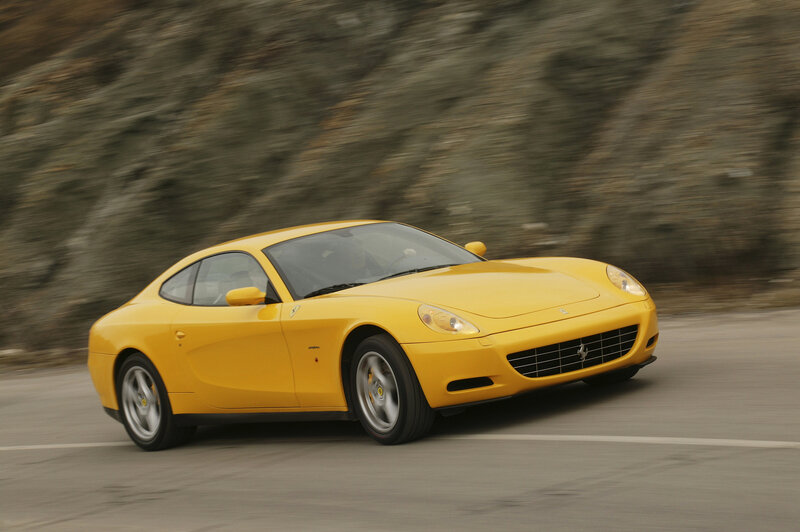 Yellow Ferrari driving on road