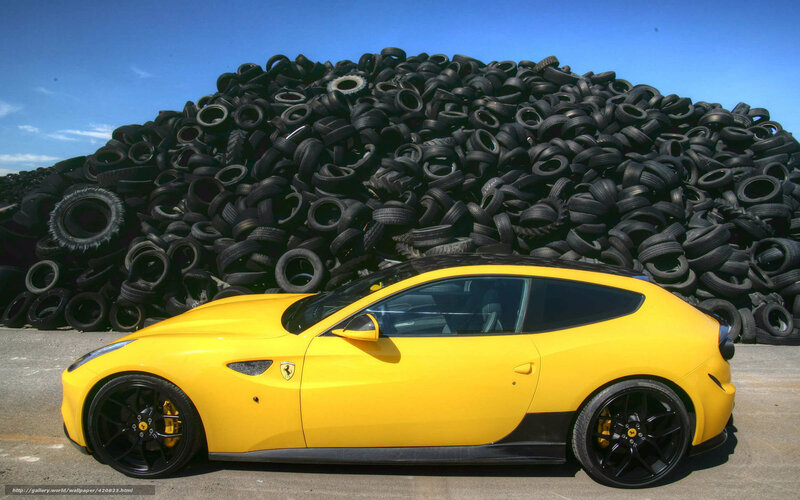 Yellow Ferrari in front of tire pile