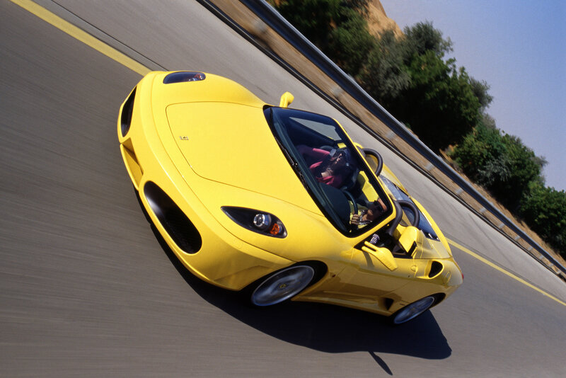 Yellow Ferrari on a winding road