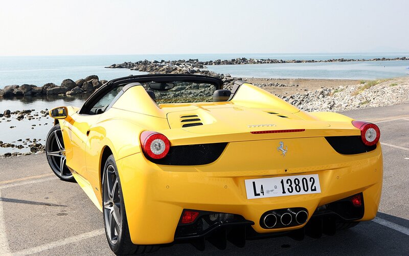 Yellow Ferrari on coastal road