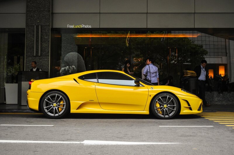 Yellow Ferrari parked outside building