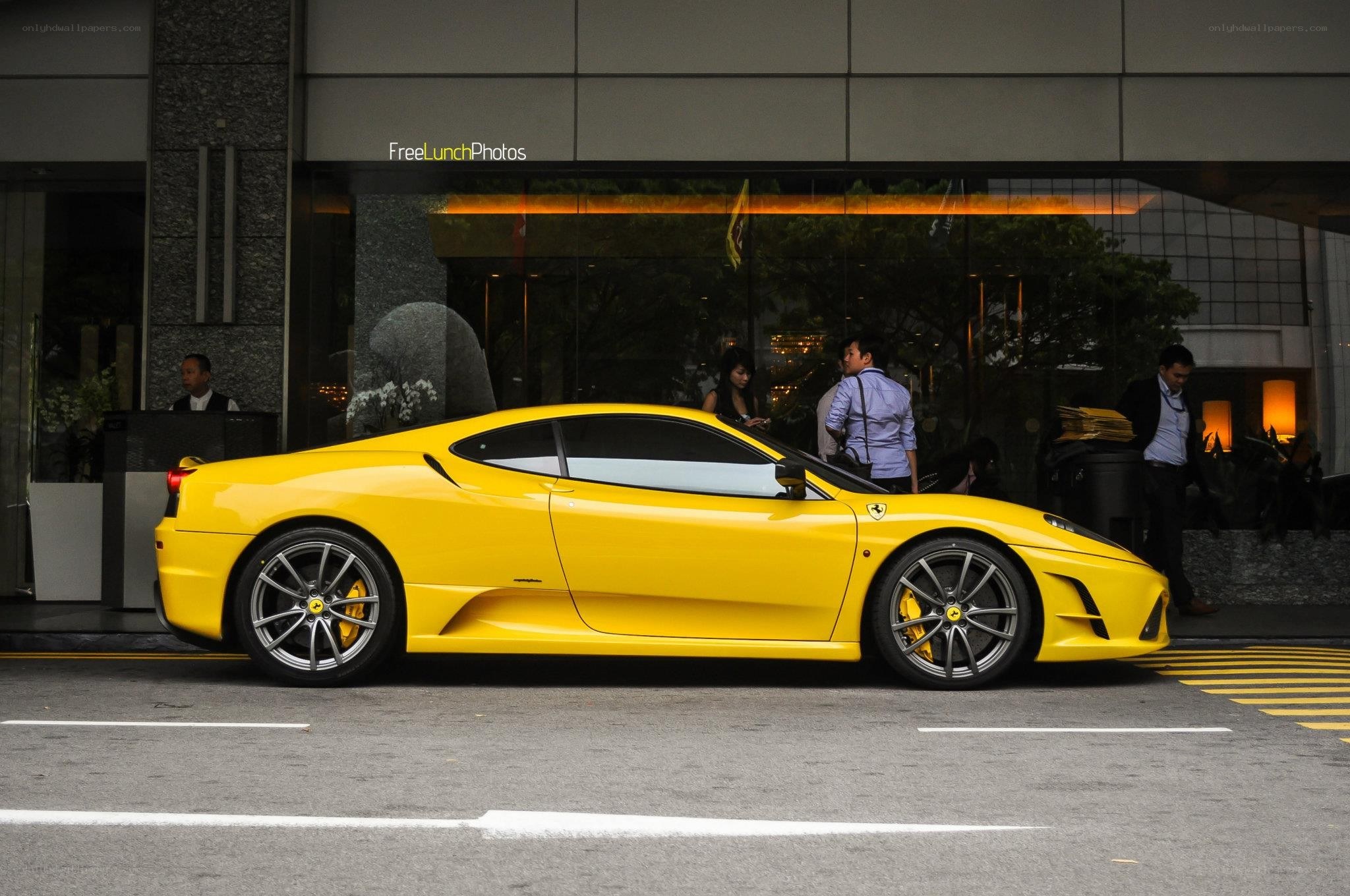 Yellow Ferrari parked outside building