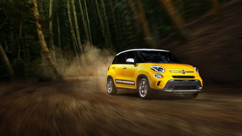 Yellow Fiat driving on dirt road