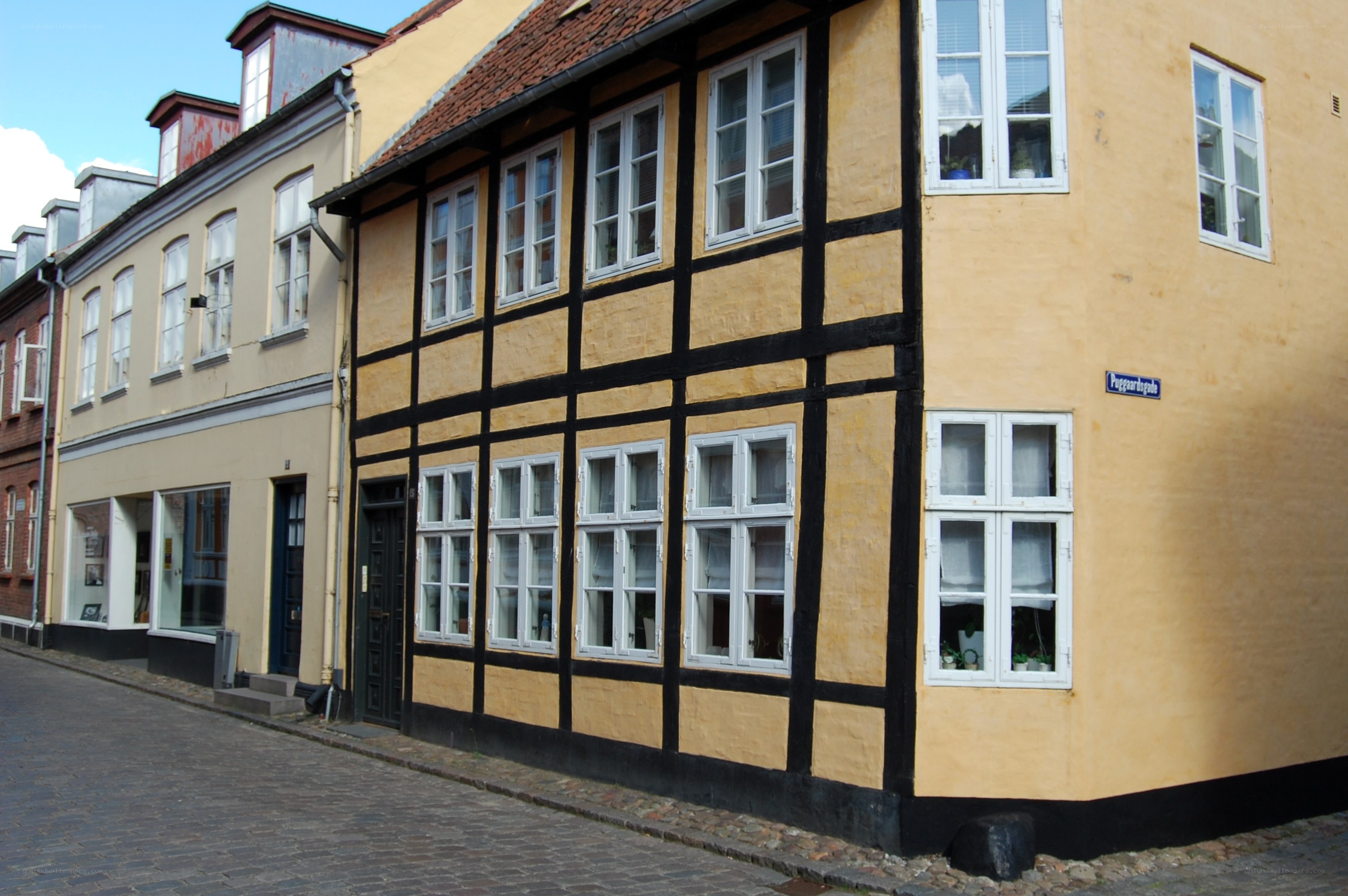 yellow half-timbered house on cobblestone street
