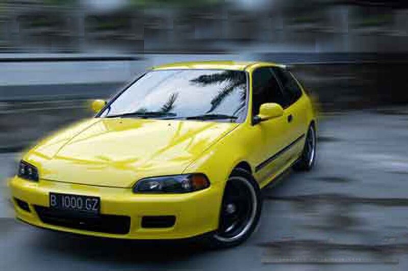 yellow hatchback in motion