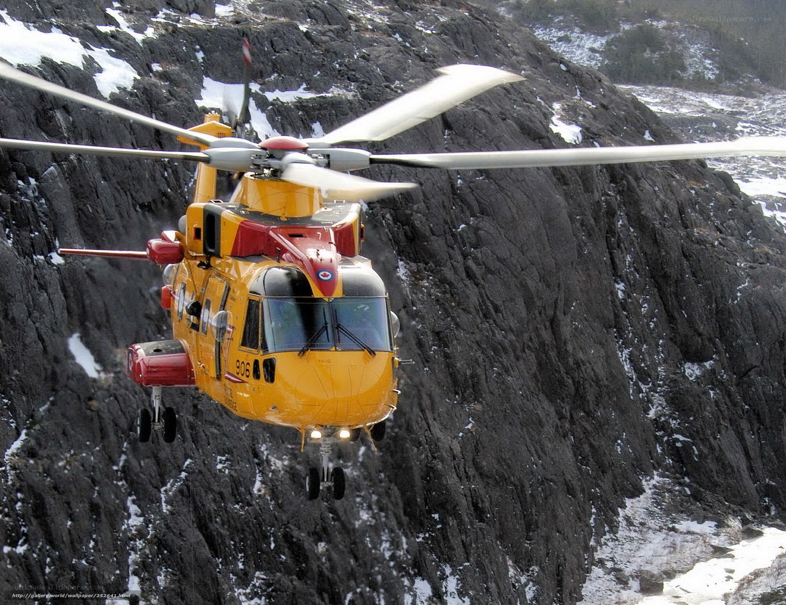 Yellow helicopter over rocky cliff