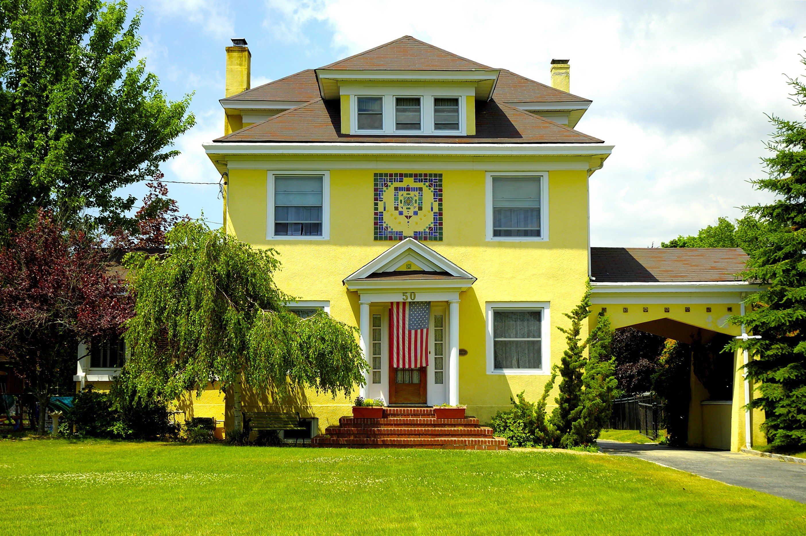 yellow house with mosaic art