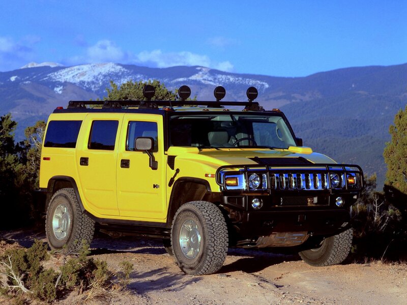 Yellow Hummer H2 in mountain landscape