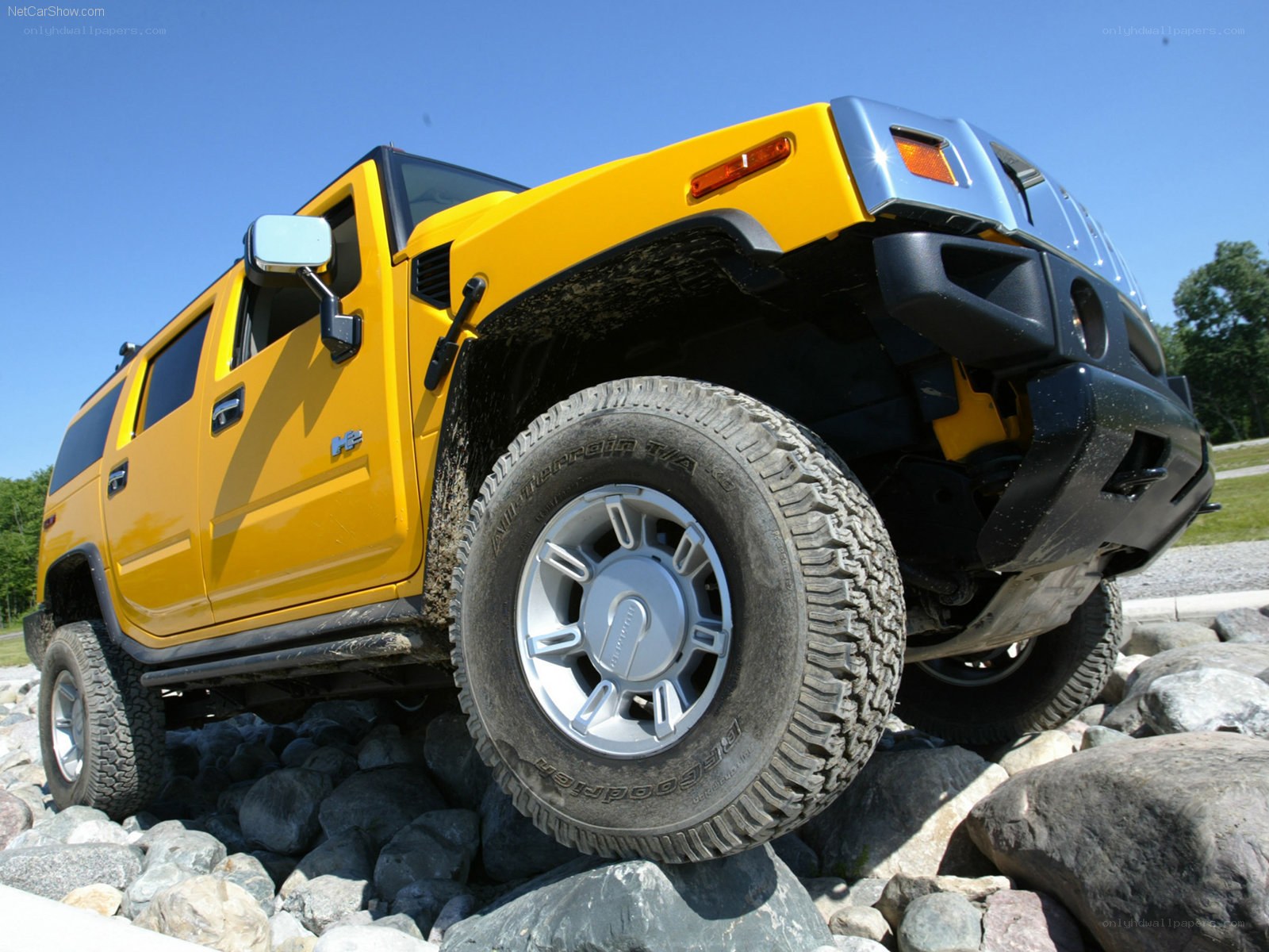 Yellow Hummer H2 on rocks