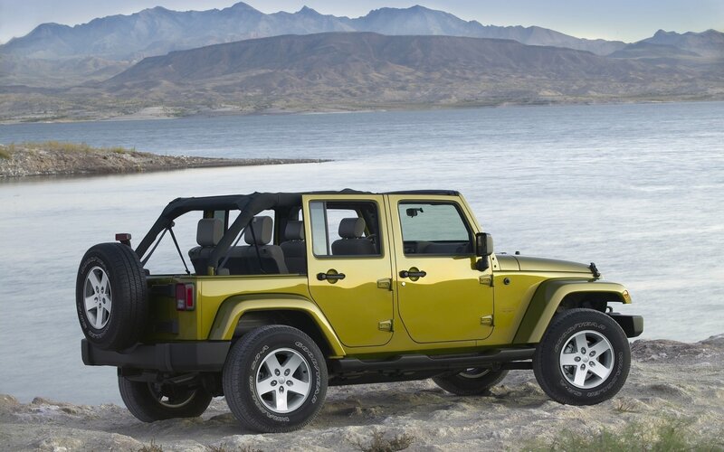 Yellow Jeep on a lakeside cliff