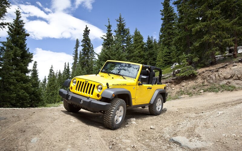 Yellow Jeep Rubicon on dirt road