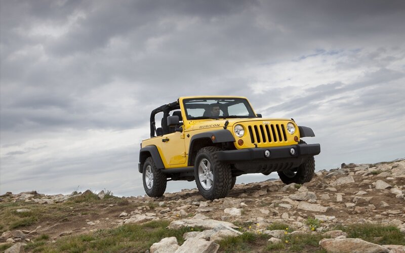 Yellow Jeep Rubicon on rocky terrain
