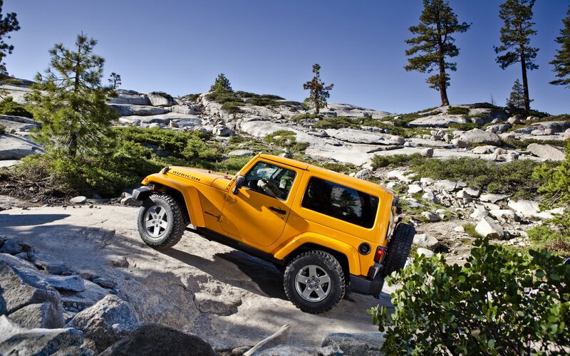 Yellow Jeep Rubicon on rocky terrain