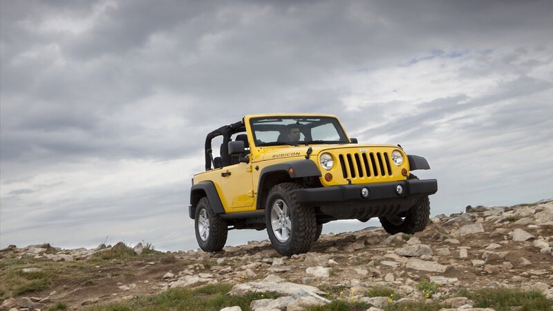 Yellow Jeep Rubicon on rocky terrain