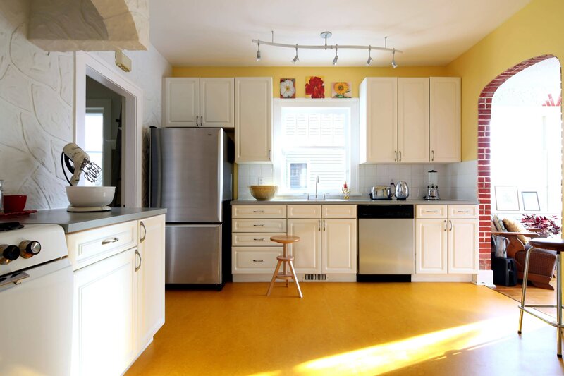 yellow kitchen with white cabinets