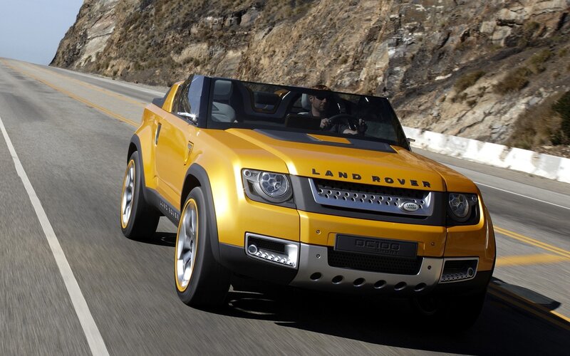 Yellow Land Rover driving on road
