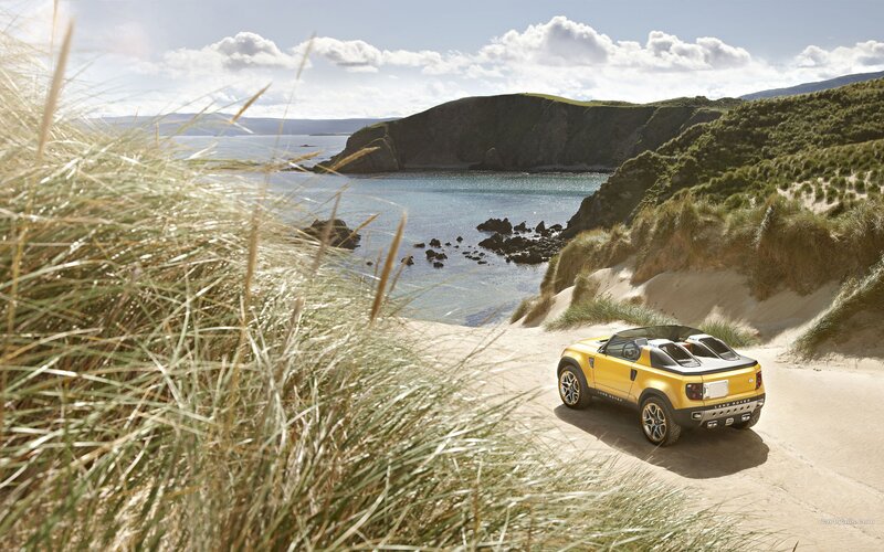 Yellow Land Rover on a coastal dune