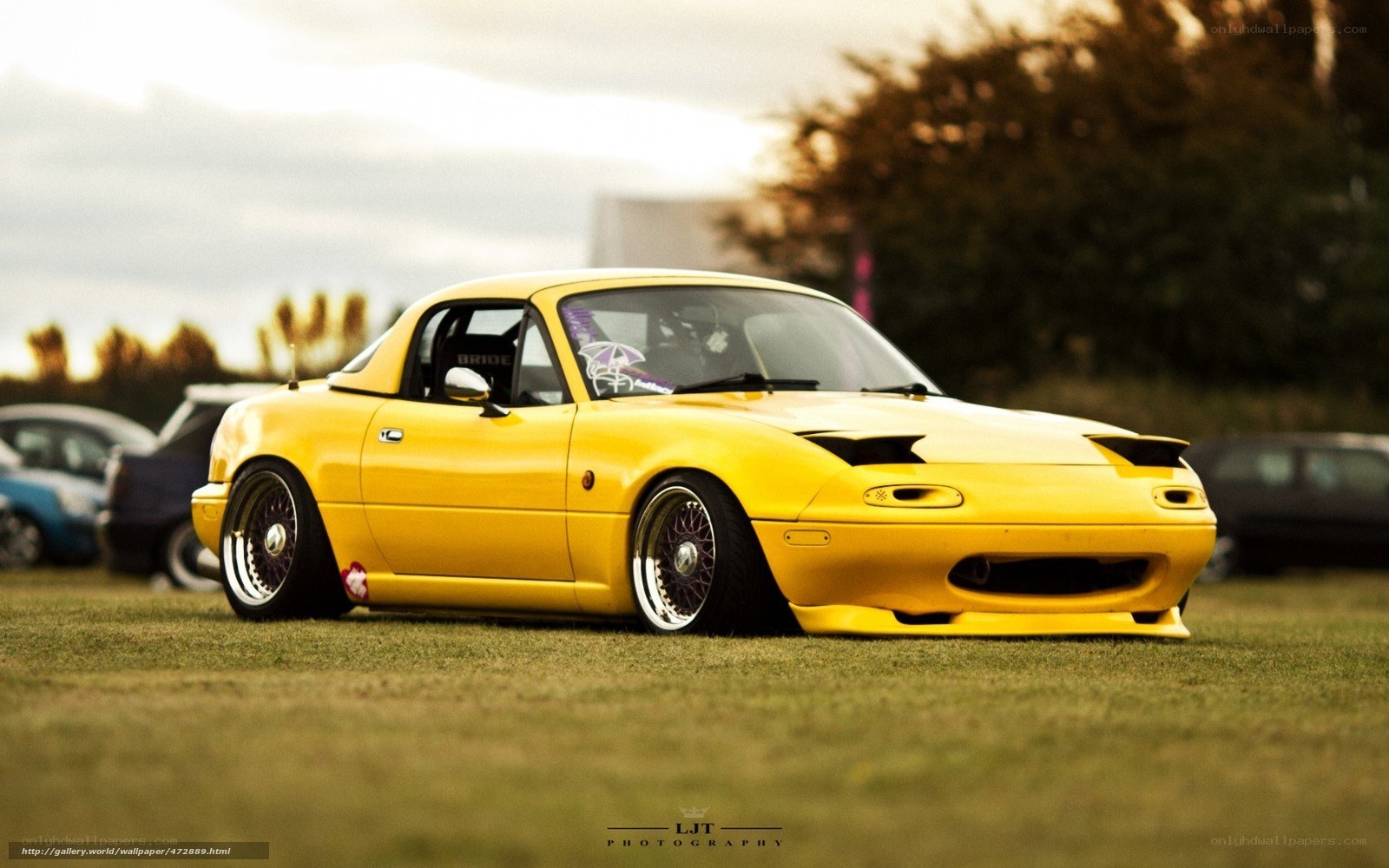 yellow mazda miata on grass