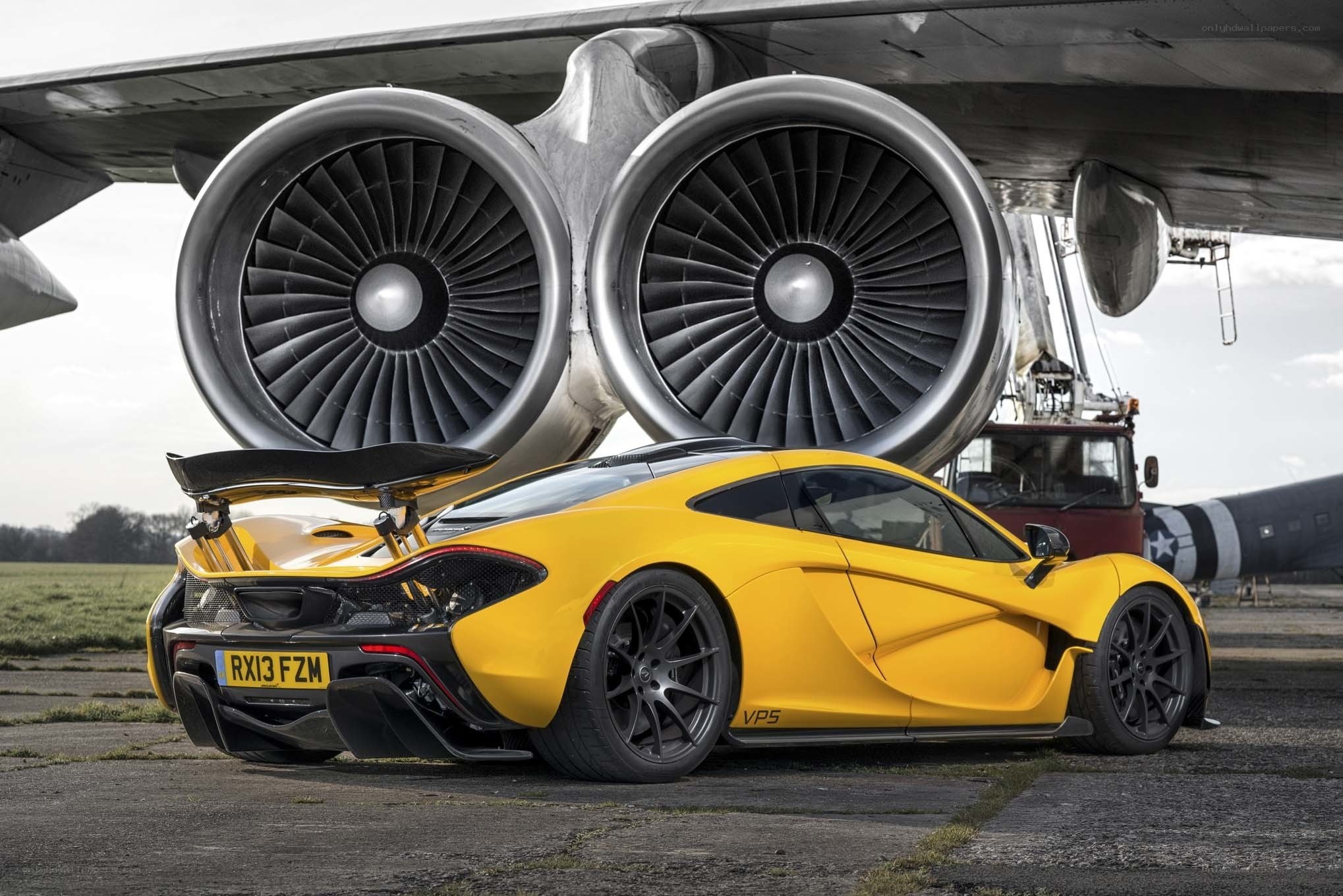 Yellow McLaren MP4-12C in front of jet