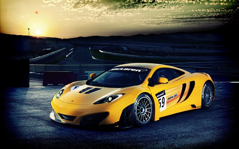 Yellow McLaren race car at sunset